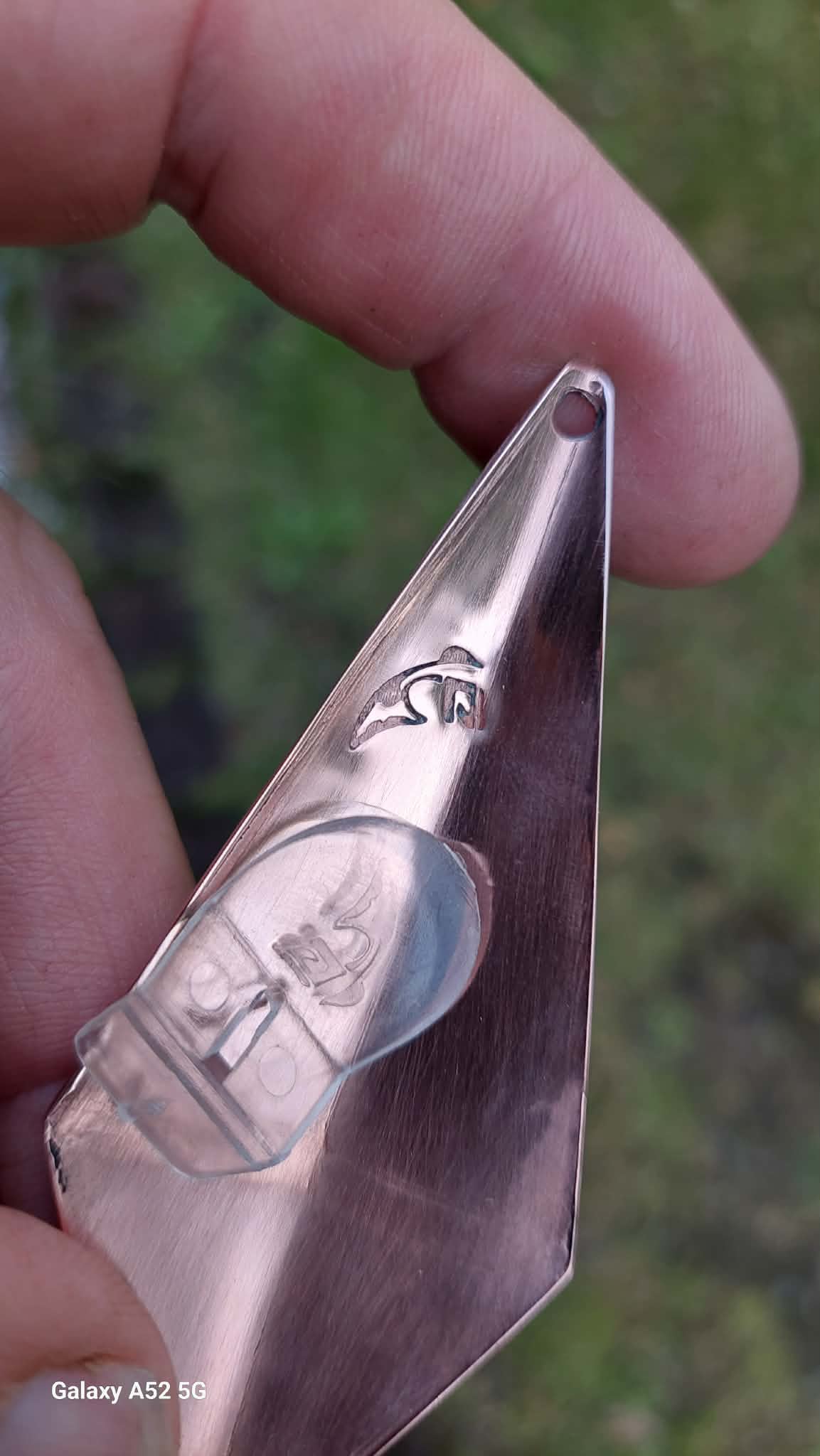 A copper lure with a maker’s mark stamped into the metal